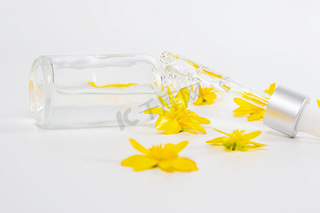 黄色春花中白色背景中带吸管血清的瓶子
