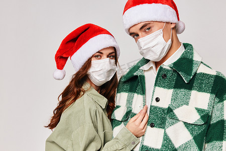 戴着医用口罩的年轻夫妇圣诞帽假期特写