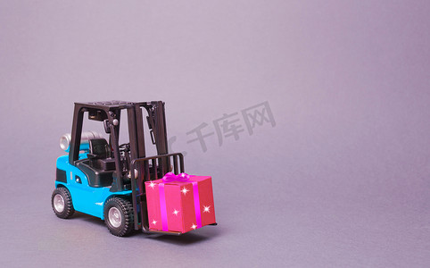 蓝色叉车运载着一个带蝴蝶结的粉色礼盒。