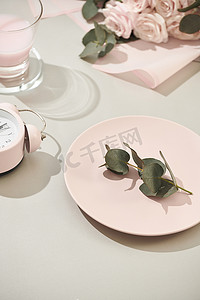 女士用品摄影照片_桌上摆着一束粉红玫瑰、盘子和草莓牛奶的女士用品