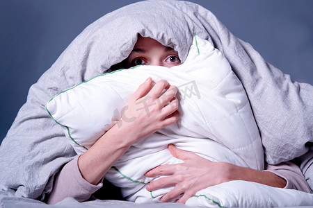 女人盖着毯子，担心失眠、压力大。