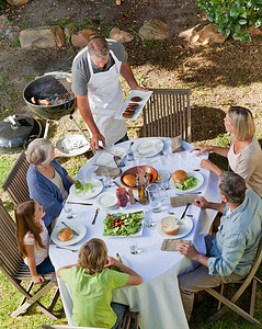 可爱摄影照片_可爱的家庭在花园里吃饭