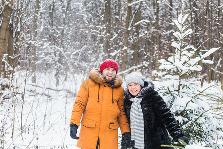 爱情、季节、友谊和人的概念 — 快乐的年轻男女在冬季森林里玩雪