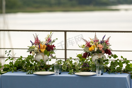 蜡烛城堡摄影照片_婚礼餐桌装饰，城堡的桌子上放着鲜花，烛光晚餐的餐桌装饰。带蜡烛的晚餐