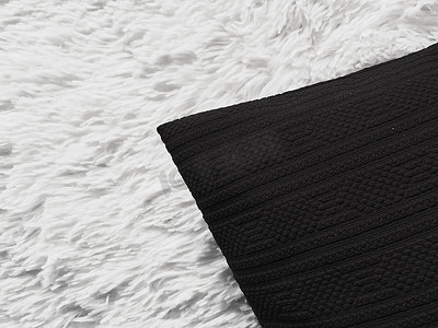 卧室黑暗摄影照片_白色蓬松格子毯上的黑色垫枕作为平躺背景、卧室顶视图和家居装饰