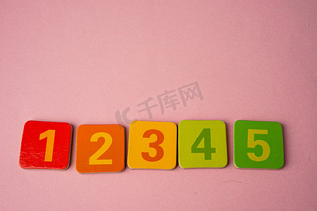 数学数字在粉红色背景下色彩缤纷，教育学习数学学习教学理念。