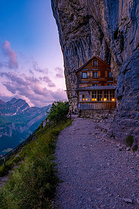 房屋山摄影照片_瑞士阿尔卑斯山和 Aescher 悬崖下的山间餐厅，从瑞士阿彭策尔地区的 Ebenalp 山望去 Aescher 悬崖