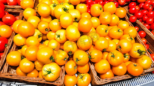 商城服务摄影照片_超市货架上盒子里的黄色西红柿。
