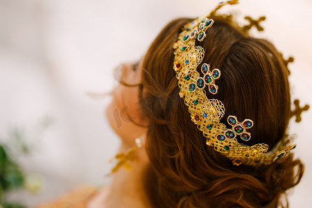 一个发型漂亮的女人，头戴镶有宝石的金冠，特写。