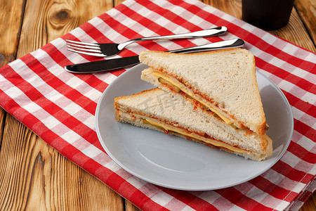烤面包三明治和一杯咖啡放在木桌上的餐巾纸上