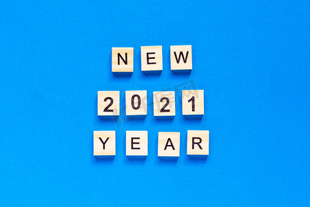 开工2021大吉摄影照片_新年快乐写在蓝色背景上的木制字母。 
