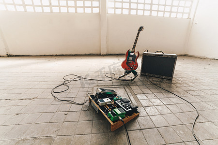 带放大器的电吉他和工作室地板上的电吉他踏脚盒效应器和电缆