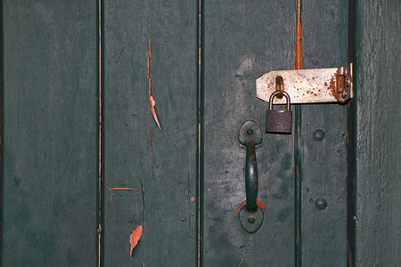 已解锁摄影照片_带闩锁和挂锁特写的彩绘旧门
