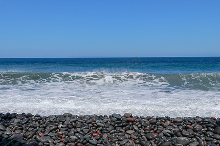 海上三四点有小风暴，海浪带着大卵石冲击岸边。