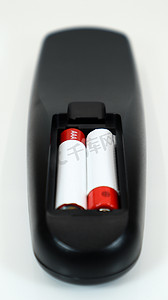 有在红色和白色的AAA碱性电池的黑电视遥控在白色背景。