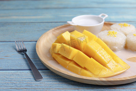 芒果皮摄影照片_新鲜的黄色芒果皮和切片的立方体与糯米，椰子