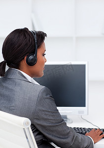 戴着耳机在电脑前工作的严肃女商人