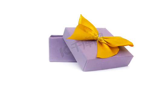 黄色丝带摄影照片_白色背景中突显的带黄色丝带蝴蝶结的空白开放式紫色礼盒