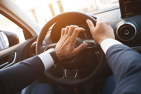 一名男子驾驶汽车的特写镜头，他的手放在喇叭按钮上。