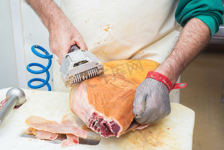 中工背景摄影照片_伊比利亚火腿切割工业过程中工人手的特写