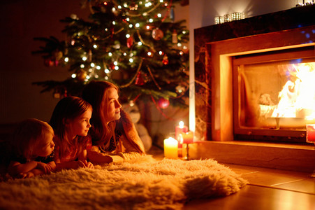 圣诞节壁炉摄影照片_圣诞节壁炉旁幸福的家庭