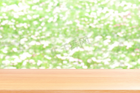 模糊的花白色和绿色软背景上的木板，模糊的花白色或草软花园自然背景上的空木桌地板，空的木桌板用于模拟展示产品