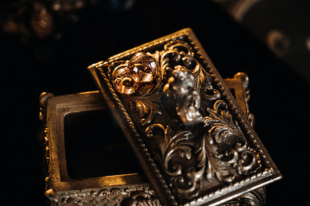 金结婚戒指放在古董珠宝盒上。