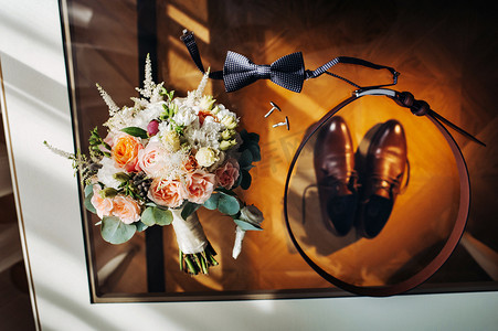 胸花新娘摄影照片_婚礼花束，桌上有玫瑰，还有胸花。婚礼上的装饰