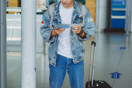 拿着护照和机票的亚裔男性游人