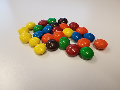白色表面或桌子上的彩色巧克力糖