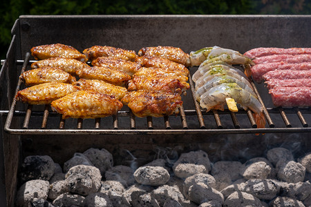 大虾摄影照片_各种腌制肉、鸡肉和大虾在烧烤炉上用热煤烧烤
