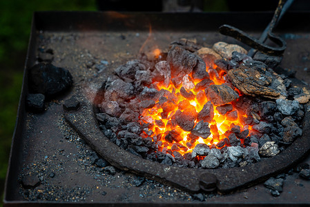 热的物品被插入铁匠的熔炉中，从那里发出火焰的舌头。