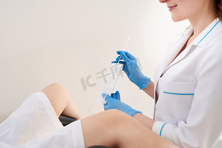 性病摄影照片_妇科医生使用阴道拭子对年轻患者进行性病检测