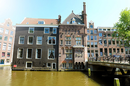 阿姆斯特丹摄影照片_荷兰阿姆斯特丹-2018 年 6 月 6 日：阿姆斯特丹运河上漂亮的房子，有桥和自行车，荷兰阿姆斯特丹
