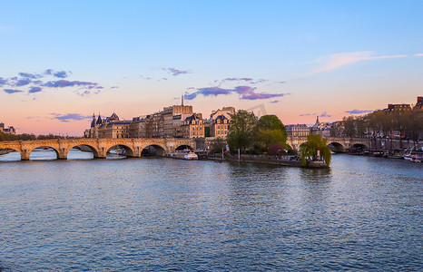 巴黎/法国 — 2019年4月4日：日落时横跨塞纳河的最古老的桥梁（新桥）和巴黎的历史建筑