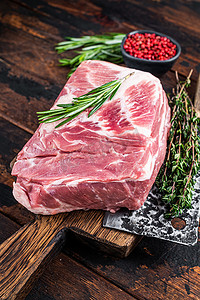 新鲜的猪颈生肉 用屠夫切肉刀在木制切菜板上切碎牛排。