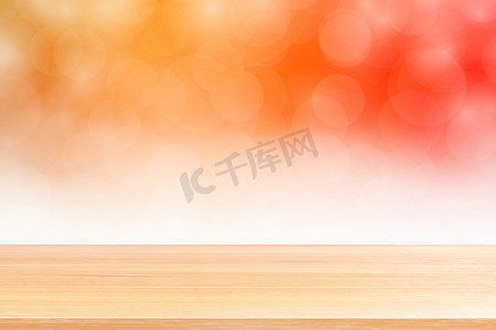 模糊的散景柔和橙色白色渐变背景上的空木桌地板，散景彩色浅色上空的木板，用于横幅广告产品的彩色散景灯渐变柔和
