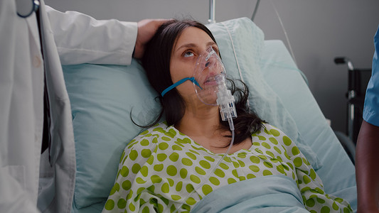 医生给生病的女人戴上氧气面罩的特写