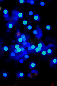 圣诞树在夜间散焦的蓝色散景灯。