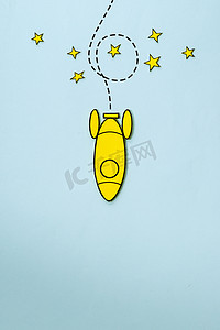小火箭摄影照片_小黄色火箭绕着星星旋转，有复制空间