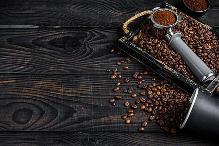 磨碎的咖啡在 Portafilter 中，用于浓缩咖啡，放在木托盘中，并配有咖啡豆。