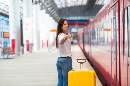 年轻的白人妇女带着行李在车站乘火车旅行
