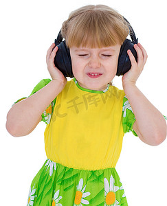 非常喜欢音乐的小女孩通过大的黑色耳机听音乐很开心。