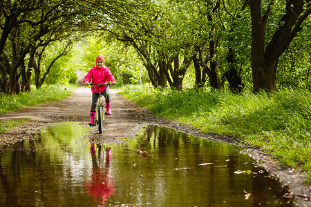 小女孩在水坑里骑自行车