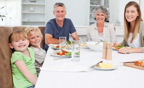 漂亮的一家人一边吃饭一边看着镜头