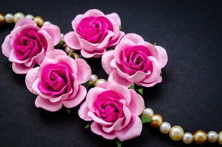 粉红玫瑰搭配珍珠项链。