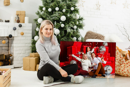 在圣诞内饰的背景上拿着照片画布的女人