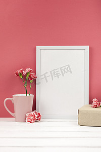 康乃馨鲜花礼盒杯白色空框桌。