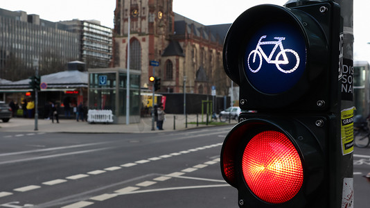 德国杜塞尔多夫 — 2020 年 2 月 28 日：德国十字路口的自行车红绿灯，背景是一座繁忙的城市。