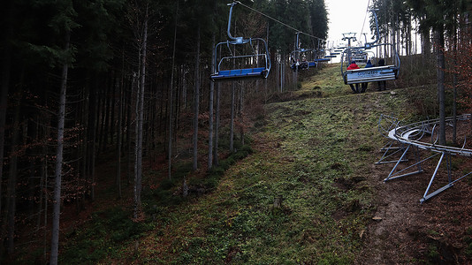 乌克兰，Bukovel - 2019 年 11 月 20 日。在秋季山坡和冬季滑雪胜地建设中的基础设施背景下，带缆车的滑雪胜地的秋季景色。